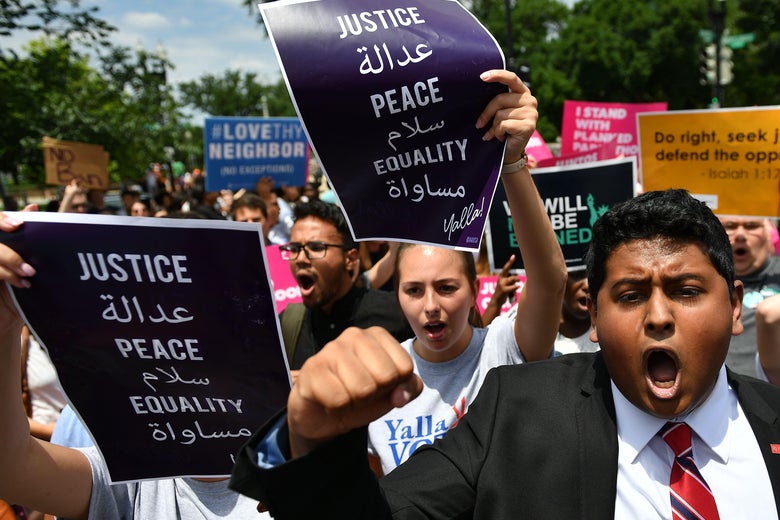 People protest the Muslim travel ban outside of the U.S. Supreme Court.